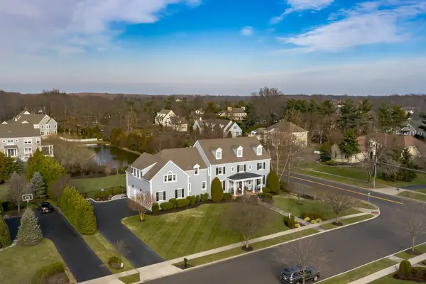 Aerial view of a home, landscaped grounds and neighborhood