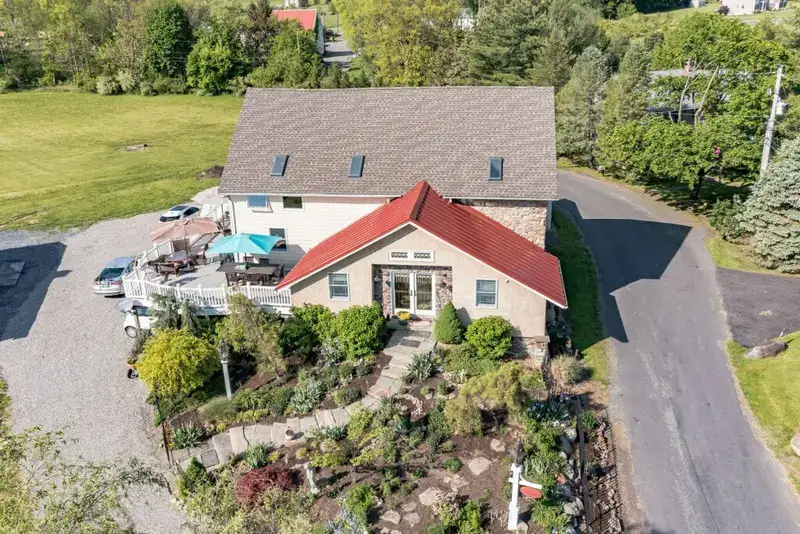 Elevated view of a home with a landscaped garden and a curved driveway