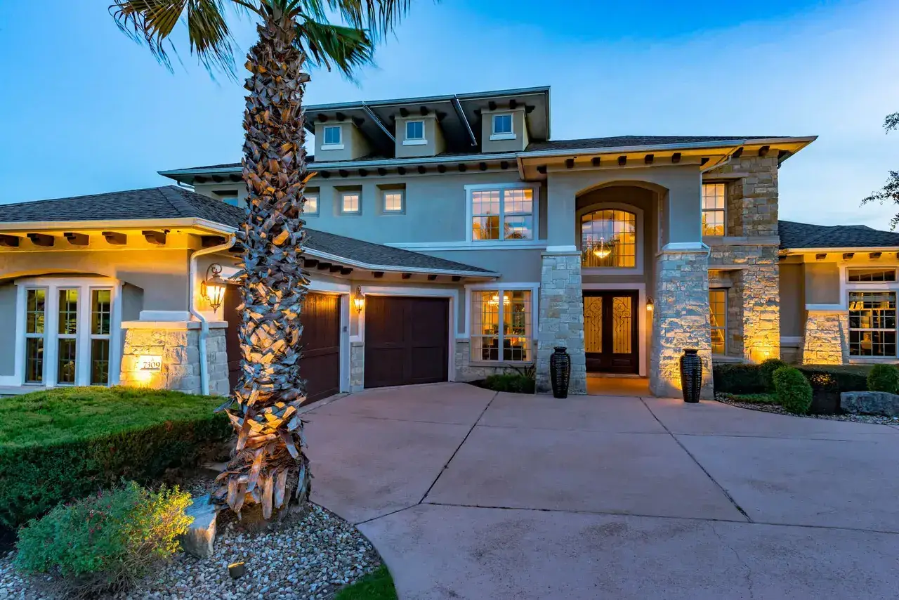 Home at twilight with a palm tree and warm exterior lighting
